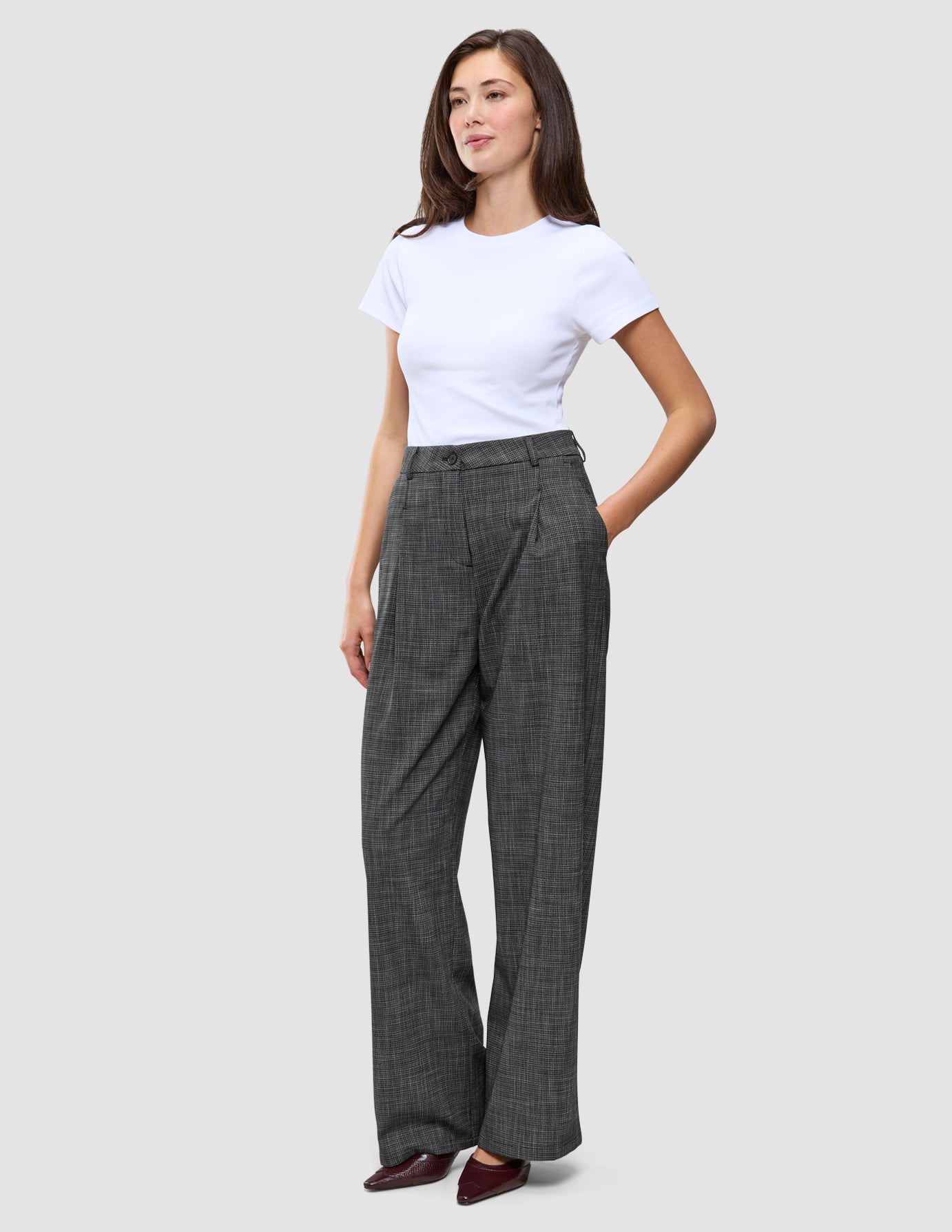 En person har en hvid T-shirt på, der er stukket ned i et par Women Nara Pants Wide Black Check.